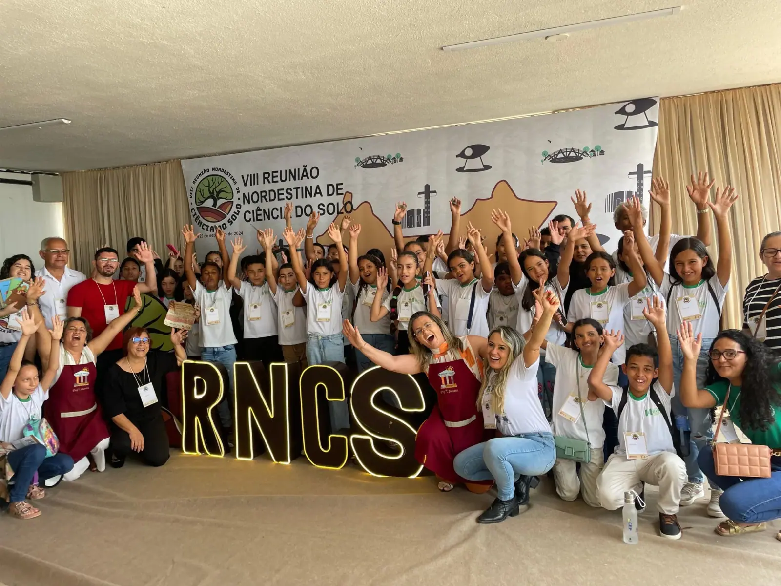 Estudantes e pesquisadores com as mãos ao alto na VIII Reunião Nordestina de Ciência do Solo